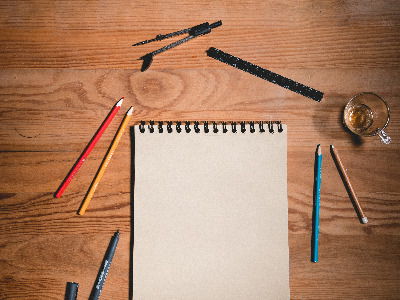 A notepad and pencils on a desk